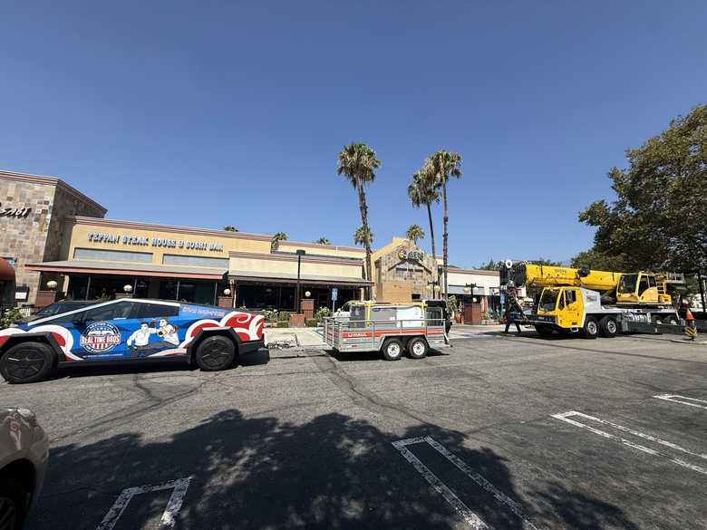 Service vehicles and crane at a retail center