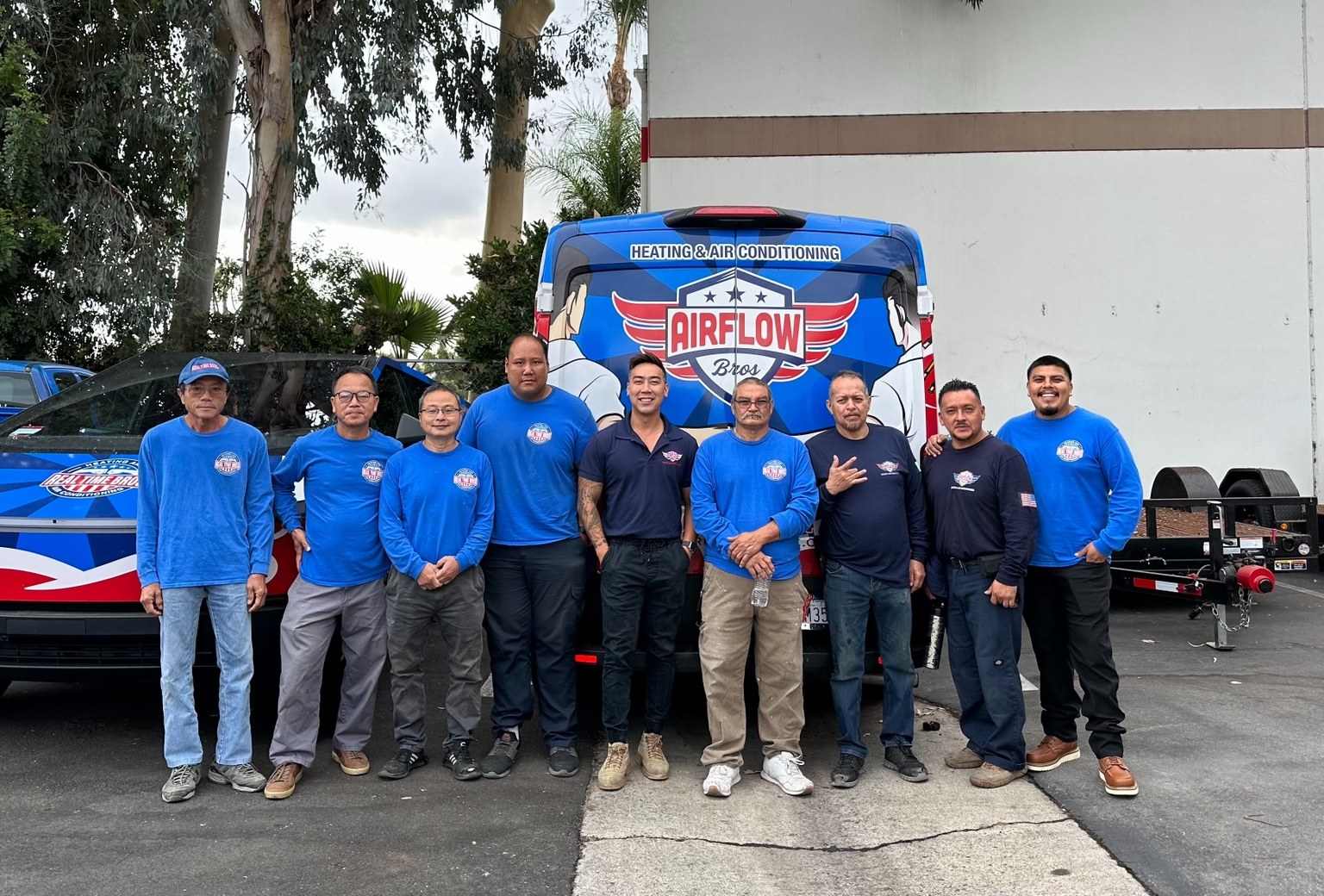 Eleven team members standing in front of a wrapped service van